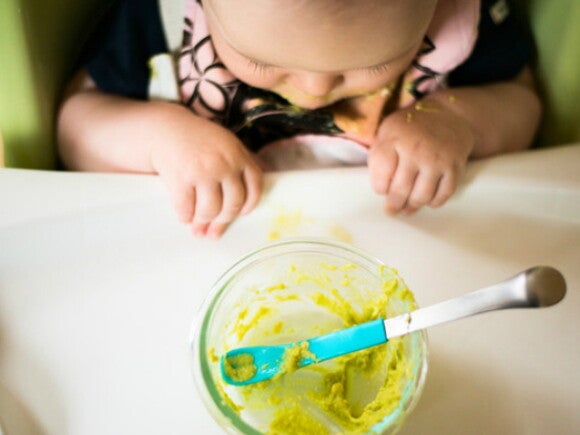 Un bambino mentre mangia le sue prime pappe