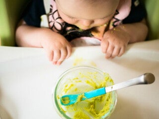 Un bambino mentre mangia le sue prime pappe